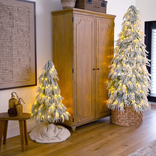 two white Christmas trees of different heights