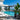 Pool deck with faux plants and a city view